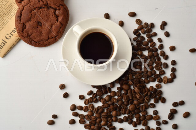 فنجان قهوه سوداء مع قطع الكوكيز اللذيذه,  قهوة اسبرسو داكنه, رقائق البسكويت بالشوكولاته, حبوب البن المتناثره