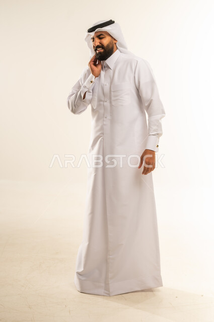 مشاكل التهاب اللثة وتسوس الأسنان, الاشارة إلى الفم بتعابير الإرهاق والتعب, بورتريه لرجل عربي خليجي قطري يرتدي الثوب التقليدي والغتره يضع يده على فمه بإيماءات الانزعاج والألم الشديد، صورة الجسم بالطول الكامل، خلفية بيضاء