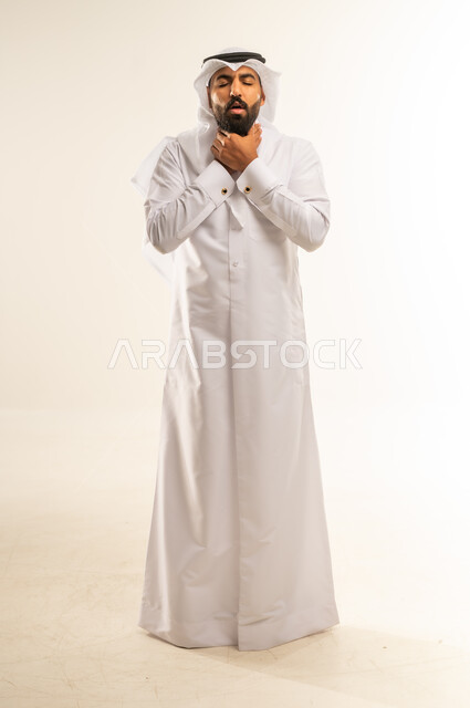 الشعور بآلام في الحلق، أمراض البلعوم والتهاب اللوزتين، الاحساس بالاختناق وعدم القدرة على التنفس، بورتريه لرجل عربي خليجي قطري يرتدي الثوب التقليدي والغتره يضع يديه حول عنقه بإيماءات المعاناة والتوجع، الجسم بالطول الكامل، خلفية بيضاء