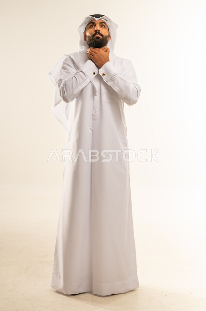 الاحساس بالاختناق وعدم القدرة على التنفس، الشعور بآلام في الحلق، أمراض البلعوم والتهاب اللوزتين، بورتريه لرجل عربي خليجي قطري يرتدي الثوب التقليدي والغتره يضع يديه حول عنقه بإيماءات المعاناة والتوجع، الجسم بالطول الكامل، خلفية بيضاء