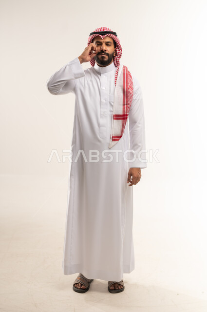مفهوم الرجولة والقوة، التهديد والتوعد لشيء ما،  الاعجاب بنمو الشارب، بورتريه لرجل عربي خليجي بحريني يرتدي الثوب التقليدي والشماغ ينظر الى الكاميرا ويمسك شاربه، إيماءات الالتزام والوفاء بالوعود، حركات وتعابير شبابيه، الطول الكامل للجسم،  خلفية بيضاء