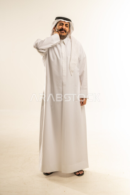 التهاب المفاصل والعضلات في الرقبة، آلام العظام والعمود الفقري، الحاجة للذهاب إلى الطبيب والمعاينة، ضرورة الاسترخاء وأخذ قسط من الراحة، بورتريه لرجل عربي خليجي قطري يرتدي الثوب التقليدي والغتره يضع يده حول عنقه بإيماءات التألم، الجسم بالطول الكامل، خلفية بيضاء