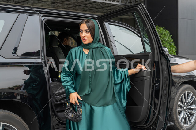 خدمة توصيل الزبائن في الإمارات العربية المتحدة, الوصول للوجهة المطلوبة، خدمات النقل الامنة, امرأة عربية خليجية إماراتية ترتدي العباءة الملونة تخرج من السيارة, شابة سعودية تستخدم التاكسي