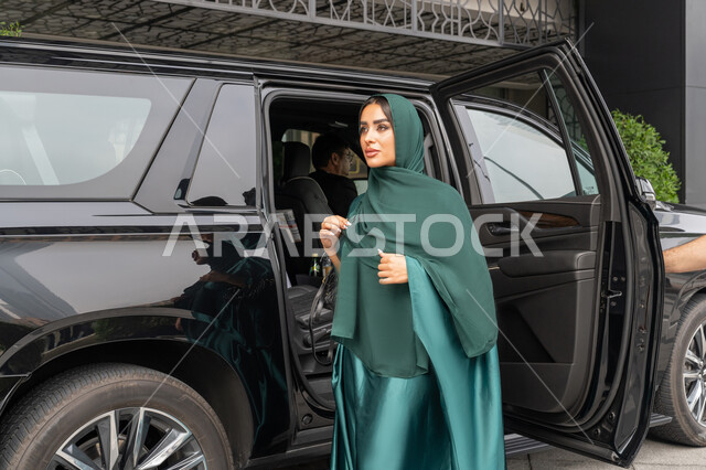 الوصول للوجهة المطلوبة، خدمة توصيل الركاب في الإمارات العربية المتحدة، خدمات النقل الامنة, امرأة عربية خليجية إماراتية ترتدي العباءة الملونة تخرج من السيارة, شابة سعودية تستخدم التاكسي