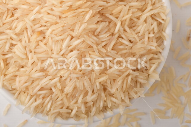 بورتريه لطبق ابيض مليئ بحبيبات الارز, محصول الارز الزراعي, ارز ابيض غير مطبوخ, أرز ابيض منثور على الأرض, محاصيل زراعيه
