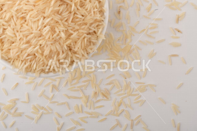 بورتريه لطبق ابيض مليئ بحبيبات الارز, محصول الارز الزراعي, ارز ابيض غير مطبوخ, أرز ابيض منثور على الأرض, محاصيل زراعيه, رز نيء