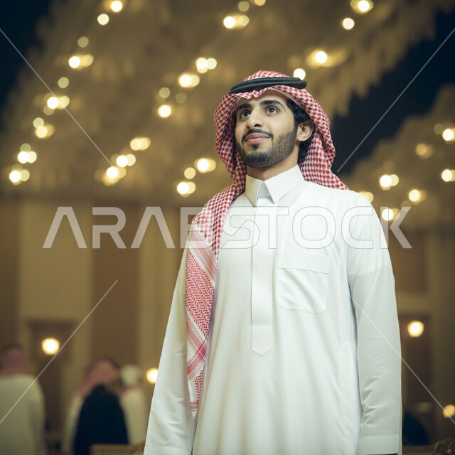Elegance and attention to external appearance, the concept of masculinity and self-confidence, standing upright and self-confident, a close-up picture of a smiling Saudi Gulf Arab man wearing a traditional dress and shemagh.