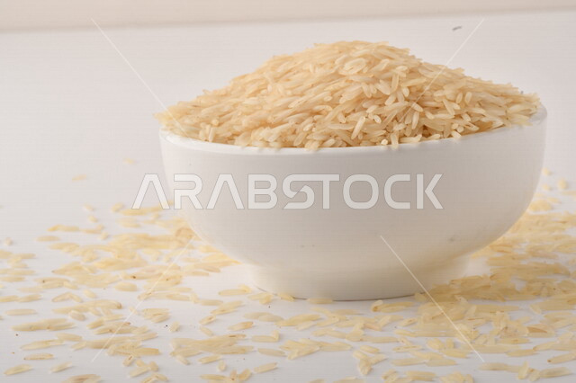 بورتريه لطبق ابيض مليئ بحبيبات الارز, محصول الارز الزراعي, ارز ابيض غير مطبوخ, أرز ابيض منثور على الأرض, محاصيل زراعيه