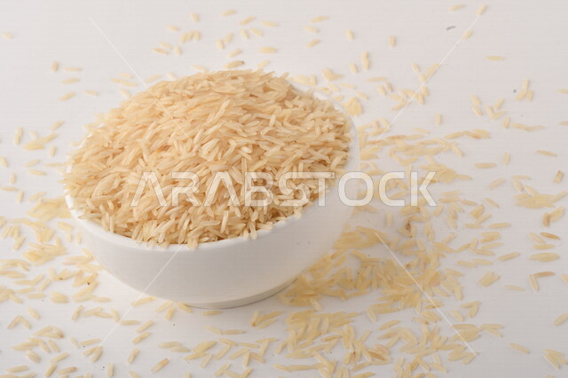 بورتريه لطبق ابيض مليئ بحبيبات الارز, محصول الارز الزراعي, ارز ابيض غير مطبوخ, أرز ابيض منثور على الأرض, محاصيل زراعيه