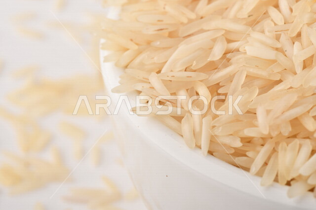 بورتريه لطبق ابيض مليئ بحبيبات الارز, محصول الارز الزراعي, ارز ابيض غير مطبوخ, أرز ابيض منثور على الأرض, محاصيل زراعيه, رز نيء