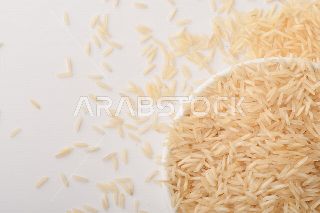 بورتريه لطبق ابيض مليئ بحبيبات الارز, محصول الارز الزراعي, ارز ابيض غير مطبوخ, أرز ابيض منثور على الأرض, محاصيل زراعيه, رز نيء