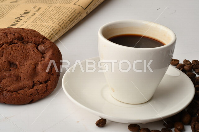 فنجان قهوه سوداء مع قطع الكوكيز اللذيذه,  قهوة اسبرسو داكنه, رقائق البسكويت بالشوكولاته, حبوب البن المتناثره