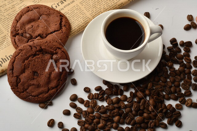 فنجان قهوه سوداء مع قطع الكوكيز اللذيذه,  قهوة اسبرسو داكنه, رقائق البسكويت بالشوكولاته, حبوب البن المتناثره
