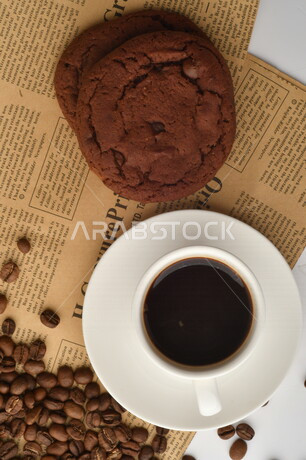 فنجان قهوه سوداء مع قطع الكوكيز اللذيذه,  قهوة اسبرسو داكنه, رقائق البسكويت بالشوكولاته, حبوب البن المتناثره