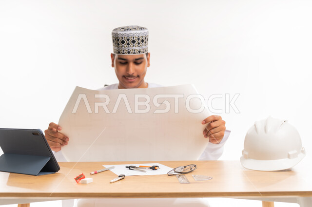 Engineering project review and design, technology integration in the educational field, study, diligence and excellence, curricula and educational materials, university education in the Sultanate of Oman, close-up portrait of an Arab Gulf Omani university student wearing a kimmah and a dishdasha studying in the engineering and construction department, white background