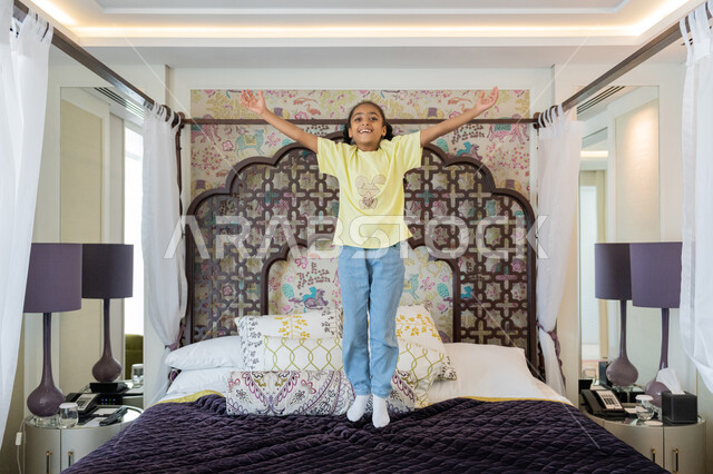 قضاء وقت ممتع باللعب والمرح، بنت سعودية تمارس الانشطة الترفيهية, الديكورات والتصاميم الداخلية لغرف النوم في الامارات العربية المتحدة, فتاة عربية خليجية اماراتية تلعب فوق السرير، ايماءات السعادة و الفرح