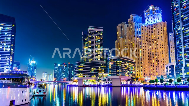 النمو والتقدم العمراني للأبراج وناطحات السحاب المضاءة في الليل، المعالم الساحلية السياحية في الإمارات العربية المتحدة، الفنادق والمنتجعات الفاخرة المطلة على الواجهة البحرية في مارينا دبي، الفن الهندسي المعماري المتطور للمنشآت التجارية والسكنية