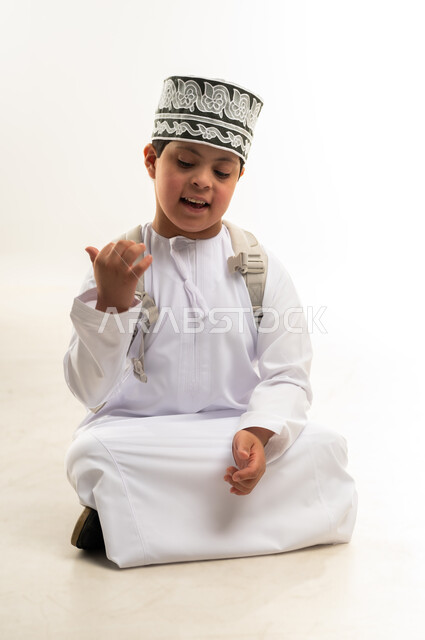 تنمية القدرات الفكرية عند ذوي الهمم، تعلم العمليات الرياضية، بورتريه لولد عربي خليجي عماني يرتدي الدشداشة والكمه يحمل حقيبة الظهر المدرسية يقوم بالحساب الذهني، جودة التعليم في مدارس سلطنة عمان، خلفية بيضاء