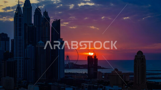 الواجهة البحرية على ساحل الخليج العربي، النمو والتقدم والتوسع العمراني، الفن الهندسي المعماري للمباني والمنشآت المطلة على البحر، منظر الأبراج وناطحات السحاب في دولة الإمارات العربية المتحدة وقت غروب الشمس، معالم دبي السياحية