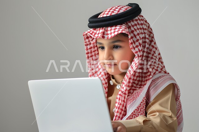 متابعه البرامج الترفيهيه المفضلة بإيماءات السرور والاندماج، بورتريه لولد عربي خليجي سعودي مبتسم يرتدي الثوب التقليدي والشماغ يقوم باستخدام جهاز الحتسوب المحمول، الاستفادة من التقنيات الحديثة في تزويد الأجيال بالمعلومات المفيدة، خلفية بيج