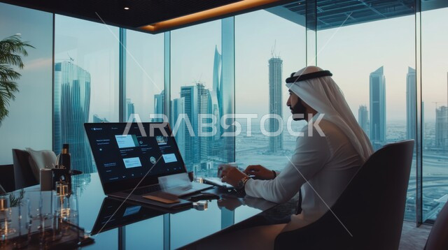 مهن ووظائف ادارية مكتبية, إدارة شؤون الأعمال وتنظيمها، استخدام الأجهزة التكنولوجية الحديثة والمتطورة، صورة من الجانب لموظف عربي خليجي اماراتي يرتدي الكندورة والغترة يقوم بالعمل على جهاز الحاسوب المحمول في داخل المكتب