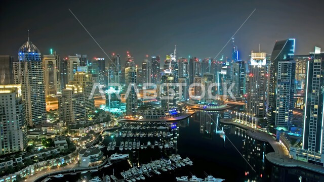 الفن الهندسي المعماري للابراج وناطحات السحاب المضيئة في وقت الليل على الطراز الحديث، المباني والمنشأت السكنية والتجارية المطلة على البحر في مدينة دبي، أماكن جذب واستقطاب السياح من شتى أنحاء العالم، الواجهة السياحية في الامارات العربي المتحدة ، النمو والتطور العمراني