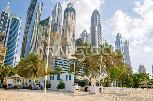 النمو والتقدم العمراني في الامارات العربية المتحدة، الفن الهندسي المعماري لبناء ابراج مارينا دبي على الطراز الحديث، أماكن سياحية ساحلية، شاطئ الميناء السياحي في منطقة جميرا في وقت النهار، مناطق جذب واستقطاب السياح من شتى انحاء العالم