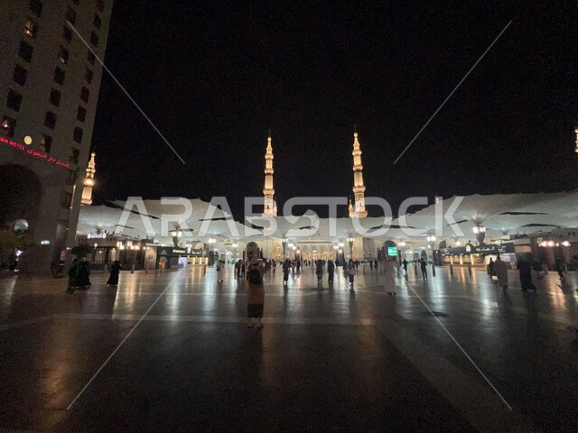 المظلات الإلكترونية في ساحة مسجد رسول الله في المدينة المنورة في وقت الليل، مفهوم العبادة والطاعة والتقرب الى الله، أماكن ومعالم دينية مقدسة في المملكة العربية السعودية، تجمع المسلمون في الساحة الخارجية للمسجد النبوي، الفن الهندسي المعماري لبناء المساجد والمآذن على الطراز الاسلامي