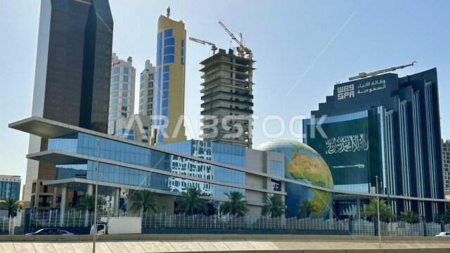 الفن الهندسي المعماري للأبراج وناطحات السحاب في وقت النهار، وكالة الانباء السعودية في مدينة الرياض في المملكة العربية السعودية، النمو والتطور العمراني للمباني مشهورة في الرياض، الاهتمام بزراعة أشجار النخيل والنباتات الخضراء