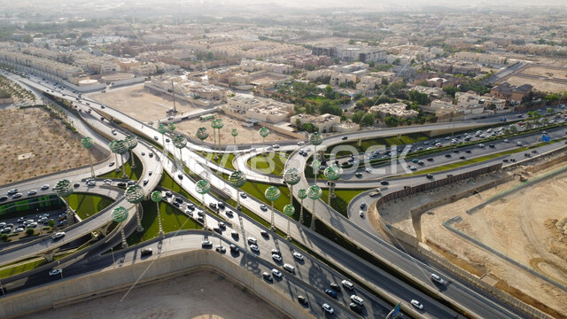 الاهتمام بزراعة النباتات الخضراء، حركة سير السيارات على الطريق السريع في مدينة الرياض، الفن الهندسي المعماري للمجسمات الفنية على شكل أشجار خضراء، الطرق المتقاطعة في دوار عرقة بالمملكة العربية السعودية، البنية التحتية المتطورة
