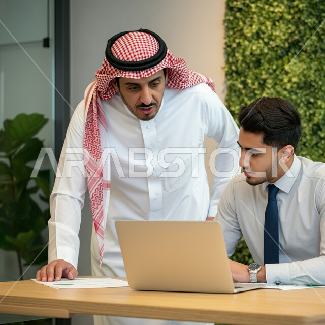 الوحدة والعمل الجماعي لتحقيق أهداف الشركة وحل المشكلات، استخدام الأجهزة والتقنيات الحديثة في الأعمال المكتبية، موظفان عربيان خليجيان سعوديان يعملان داخل المكتب، إنجاز وتحقيق المهام اليومية، مفهوم الشراكة والتعاون وتبادل الخبرات والمهارات