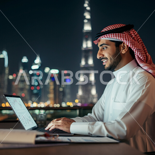 المهن والوظائف الإدارية للشباب في المملكة العربية السعودية، صورة مقربة من الجانب لرجل عربي خليجي سعودي يرتدي الشماغ و الثوب التقليدي يعمل على الحاسوب المحمول داخل مقر الشركة، استخدام الأجهزة والتقنيات الحديثة المتطورة، إدارة شؤون الأعمال وتنظيمها