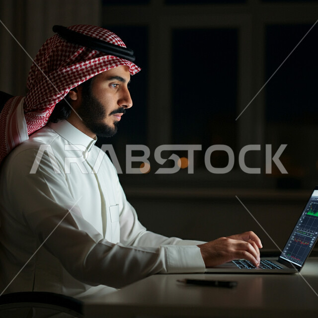 استخدام الأجهزة والتقنيات الحديثة المتطورة، إدارة شؤون الأعمال وتنظيمها، صورة مقربة من الجانب لرجل عربي خليجي سعودي يرتدي الشماغ و الثوب التقليدي يعمل على الحاسوب المحمول داخل مقر الشركة، مهن ووظائف إدارية مكتبية في المملكة العربية السعودية