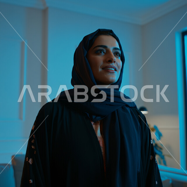 الاعتناء بالمظهر الخارجي والشياكة والأناقة, تعابير السعادة والسرور ، صورة مقربة لإمرأة عربية خليجية سعودية مبتسمة ترتدي العباءة السوداء تنظر إلى مكان ما في الأعلى بإيماءات الثقة بالنفس والفرح، مفهوم الأنوثة والنعومة لدى النساء السعوديات