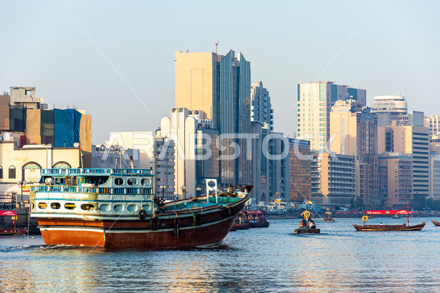 Wooden cargo ship transporting goods and merchandise in Dubai Creek area, UAE maritime economy, maritime trade through ports, commercial port for delivering local products through ships in the seas