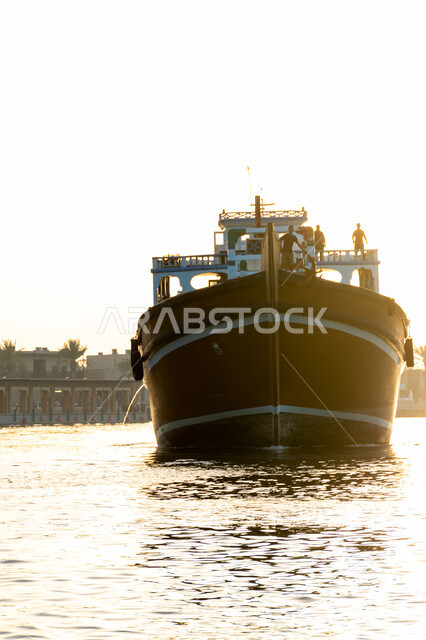 Maritime economy in UAE, maritime trade through ports, commercial port for delivering local products via ships at sea, wooden cargo ship for transporting goods and merchandise in Dubai Creek area