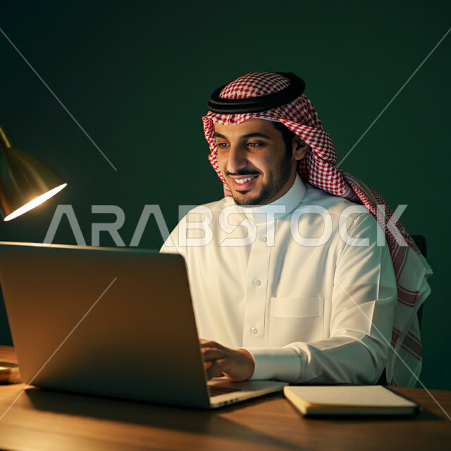 استخدام الأجهزة التقنية الحديثة، إدارة شؤون الأعمال وتنظيمها، بورتريه مقرب لرجل عربي خليجي سعودي يرتدي الشماغ و الثوب التقليدي يجلس على كرسي مريح يعمل على الحاسوب المحمول، مهن ووظائف إدارية، مفهوم إنجاز المشاريع والمهام، العمل عن بعد، خلفية خضراء