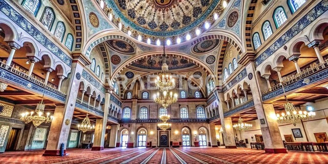 Colorful carvings and decorations on columns, walls and domes, distinctive interior designs and decorations of modern mosques, a picture from the inside of a chandelier hanging from the ceiling of the mosque, the spiritual religious atmosphere, sacred Islamic places and landmarks