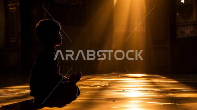 التضرع والدعاء والتقرب إلى الله تعالى, التعبد وأداء الفرائض والعبادات في الدين الإسلامي، الهداية بنور الصلاة والطاعات، ولد عربي خليجي سعودي يرتدي الثوب التقليدي يجلس ويرفع يديه ويدعو الله، الاعتكاف في المساجد ودور العبادة في جو روحاني دافئ