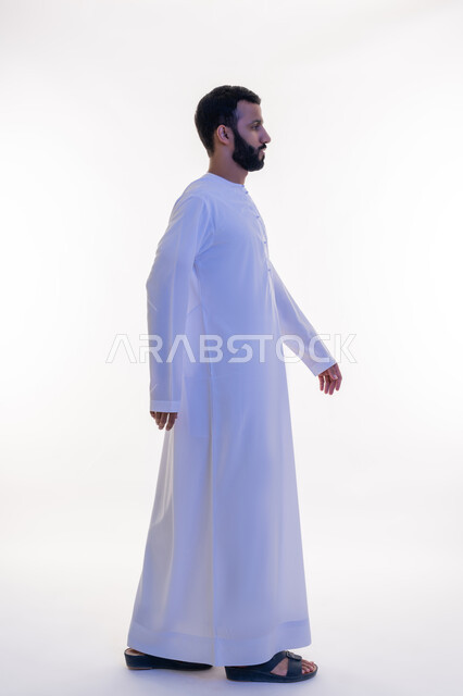 ايماءات المشي والذهاب، الاهتمام بالمظهر الخارجي, النظر الى مكان ما بتعابير الثقة بالنفس، مفهوم الأناقة والرجولة, بورتريه من الجانب لرجل عربي خليجي اماراتي يرتدي الكندورة ، التقاط الصور الشخصية للوثائق الرسمية، الجسم بالطول الكامل، خلفية بيضاء