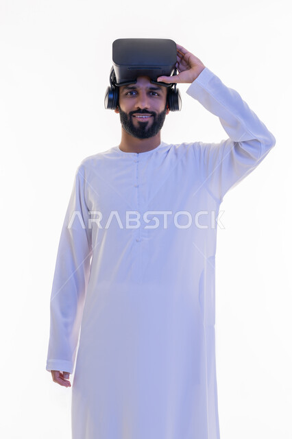 محاكاة العالم الخيالي، مشاهدة الأفلام باستخدام تقنيات الواقع الافتراضي, بورتريه لرجل عربي خليجي إماراتي يرتدي الكندورة يضع نظارة ثلاثية الأبعاد على رأسه ينظر إلى الكاميرا بإيماءات السرور، خلفية بيضاء