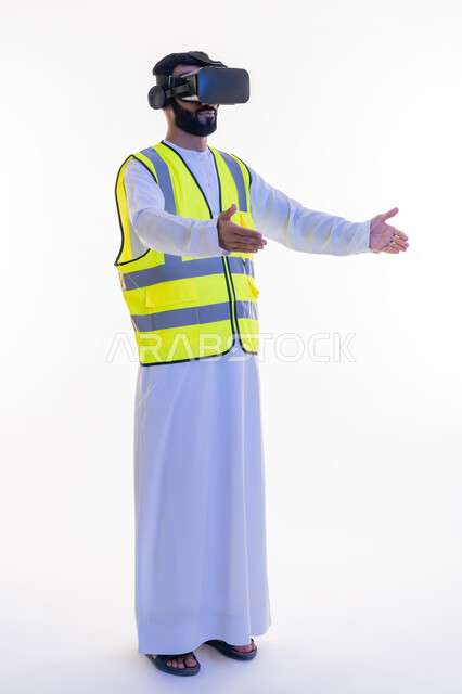 Integrating technology with engineering fields, interacting with virtual engineering, portrait of an Arab Gulf Emirati engineer wearing a kandura, work jacket and virtual reality glasses holding an item, future vision 2030, growth and development of the engineering field, full body, white background