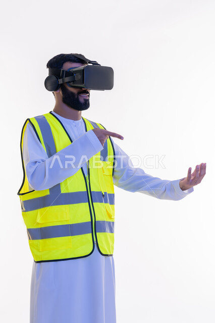 رؤية مستقبلية 2030، التفاعل مع الهندسة الافتراضية، الإشارة بإصبع السبابة إلى عناصر هولوجرلمية في كف اليد، بورتريه لمهندس عربي خليجي إماراتي يرتدي الكندورة والسترة الخاصة بالعمل ونظارة الواقع الافتراضي، دمج التكنولوجيا بالمجالات الهندسية، خلفية بيضاء