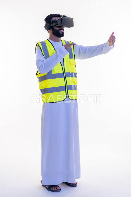 دمج التكنولوجيا بالمجالات الهندسية، الإشارة بإصبع السبابة إلى عناصر هولوجرلمية في كف اليد، بورتريه لمهندس عربي خليجي إماراتي يرتدي الكندورة والسترة الخاصة بالعمل ونظارة الواقع الافتراضي، رؤية مستقبلية 2030، الجسم بالطول الكامل، خلفية بيضاء