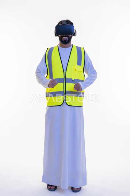 نمو وتطور المجال الهندسي، بورتريه لمهندس عربي خليجي إماراتي يرتدي الكندورة والسترة الخاصة بالعمل ونظارة الواقع الافتراضي، دمج التكنولوجيا بالمجالات الهندسية، رؤية مستقبلية 2030، إيماءات السعادة والحماس، الجسم بالطول الكامل، خلفية بيضاء
