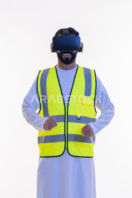 Gestures of happiness and enthusiasm, growth and development of the engineering field, interaction with virtual engineering, portrait of an Arab Gulf Emirati engineer wearing a kandura, work jacket and virtual reality glasses, integration of technology with engineering fields, future vision 2030, white background