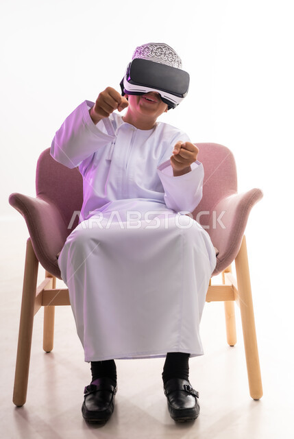محاكاة العالم الخيالي، دمج التقنيات والتكنولوجيا الحديثة مع المتعة والتسلية، بورتريه لولد عربي خليجي عماني يرتدي الدشداشه والكمه ينظر من خلال نظارات ثلاثية الأبعاد (الفي ار),  الجسم بالطول الكامل، خلفيه بيضاء