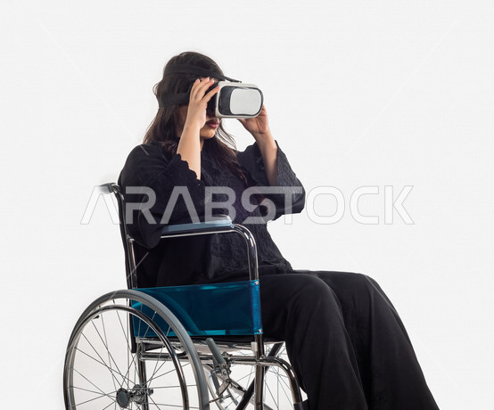 بورتريه لمرأة عربية خليجية سعودية، ، تنظر من خلال نظارات الواقع الإفتراضي (VR Box) ، مقعدة على كرسي متحرك ، الاعاقة الحركية ، خلفية بيضاء ، مفهوم ذوي الإحتياجات الخاصة ، ذوي الهمم ، التكنلوجيا المتطورة ، التسليه والترفيه