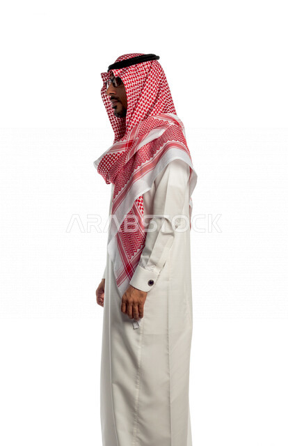 بورتريه لرجل عربي سعودي خليجي يقوم بجلسة تصوير بإيماءات وجه ويدين مختلفة ، منظر جانبي لرجل سعودي مسلم يرتدي زي تقليدي سعودي مع شماغ وعقال ، خلفية بيضاء