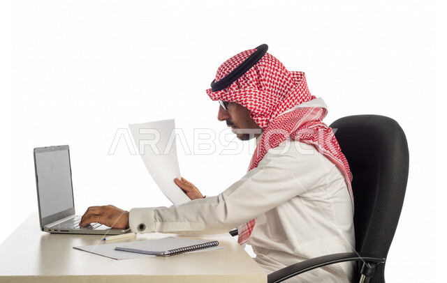 بورتريه لرجل أعمال سعودي خليجي في مقر العمل، استخدام جهاز الحاسوب المحمول لإنجاز المهام والمشاريع، جلسة عمل، العمل عن بعد، مهن وأعمال تجارية، مفهوم إدارة الأعمال، عقد صفقات عمل عبر الإنترنت، متابعة إستراتيجية المشروع، مراجعة البحوث العلمية، بيئة عمل